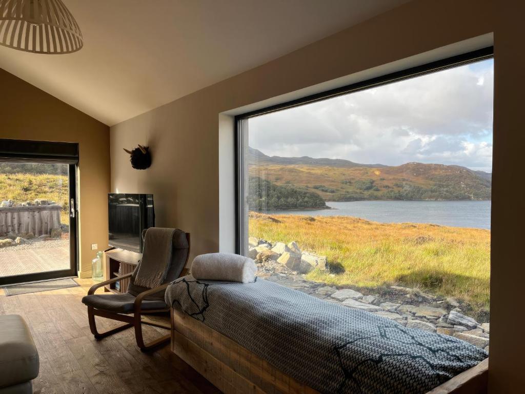 a bedroom with a large window overlooking a lake at White Cairn - Uk50484 in Kylestrome