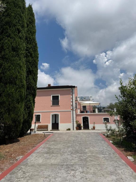 a pink building with a bench in front of it at B&B Casa Lydia in Lamezia Terme