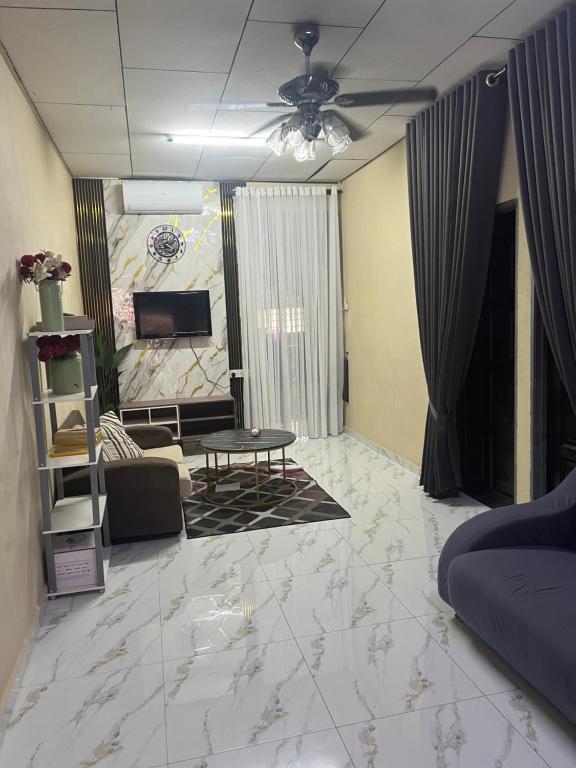 Una sala de estar con un sofá y un televisor. en laman terrace, en Sungai Petani