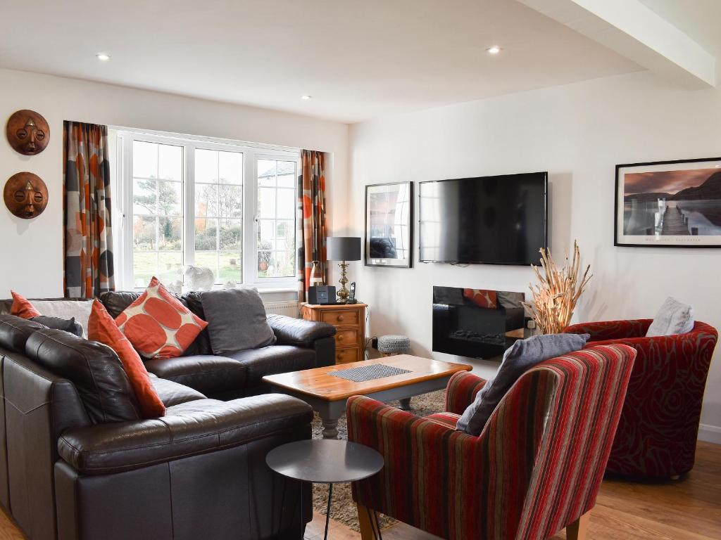 a living room with two leather couches and a tv at Mountain View in Morfa Bychan