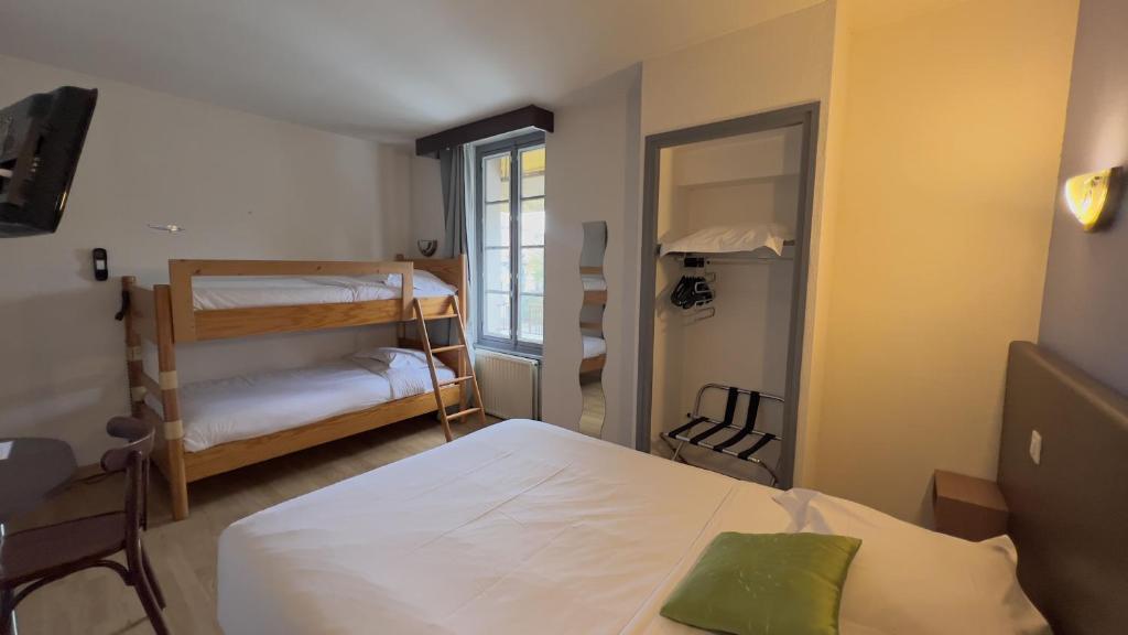 Una pequeña habitación con dos camas y un espejo. en Hôtel le Relais de Vendée, en Les Herbiers