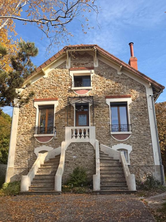 an old brick house with stairs in front of it at Pause champêtre au cœur du Vexin in Marines