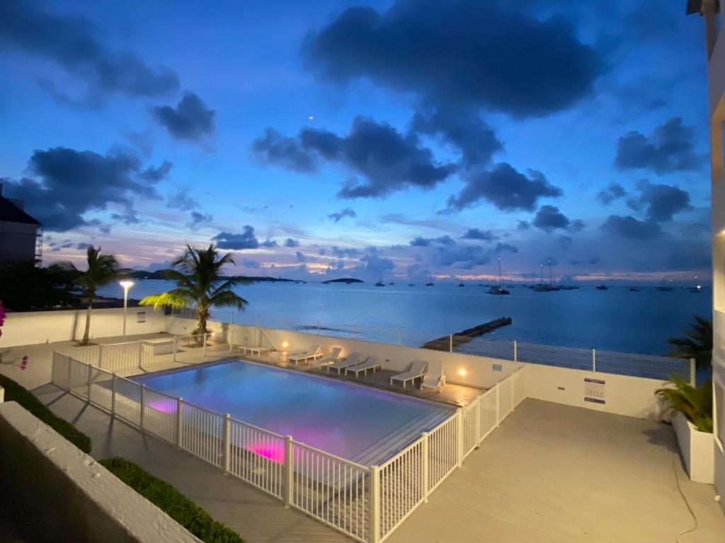 a pool with a view of the water at night at Sea view Marigot pool studio in Saint Martin