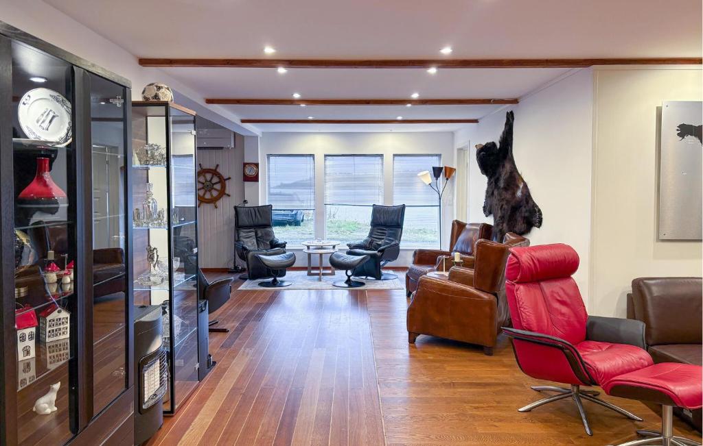 Nice Apartment In Kvalsund With Wifi في Kvalsund: غرفة معيشة مع كراسي وكلب معلق على الحائط