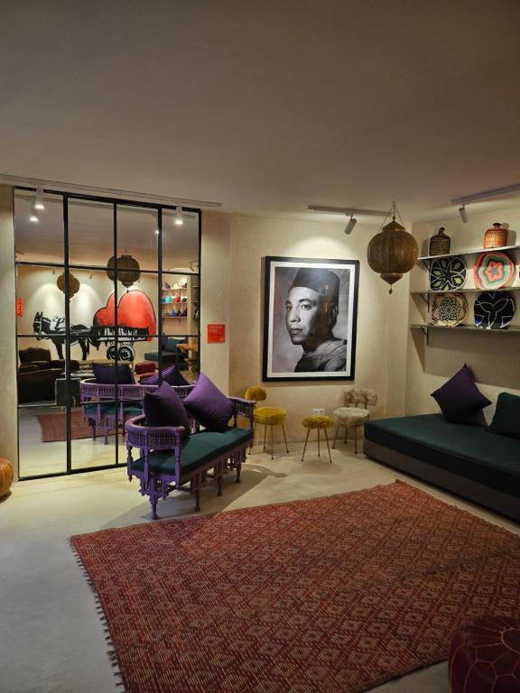 sala de estar con sillas moradas y sofá en Miostello Lifestyle Riad Marrakech, en Marrakech