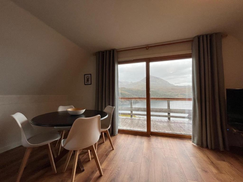a dining room with a table and chairs and a large window at Sandwood - Uk50498 in Kylestrome
