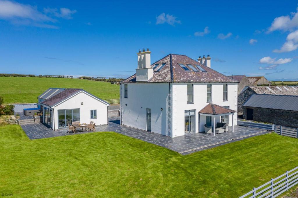 an aerial view of a white house with a yard at Bryndeusant in Llanbabo