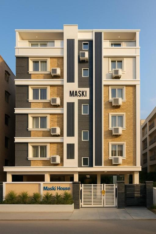 a large apartment building with a mask sign on it at Hotel Maski Suties in Kondapur