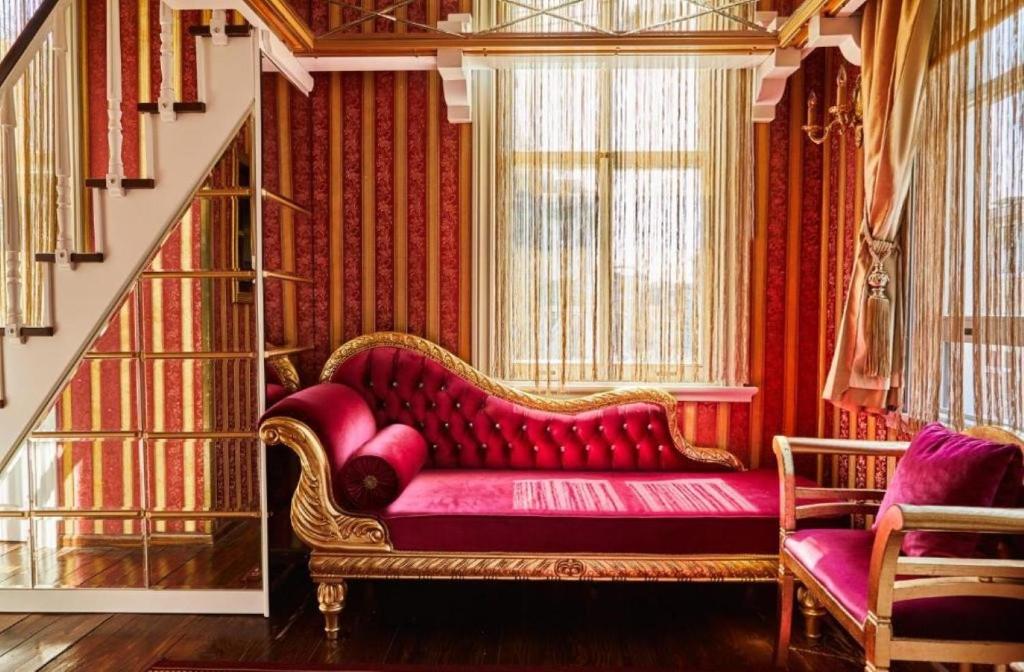 a living room with a red couch and a staircase at Sultan Suites Hotel in Istanbul