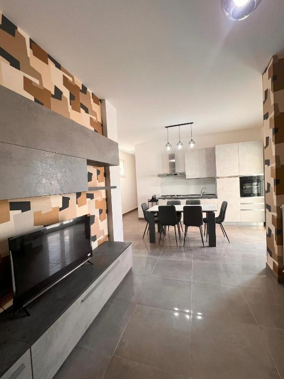 a living room with a fireplace and a dining room at Casa Dea in Paterno