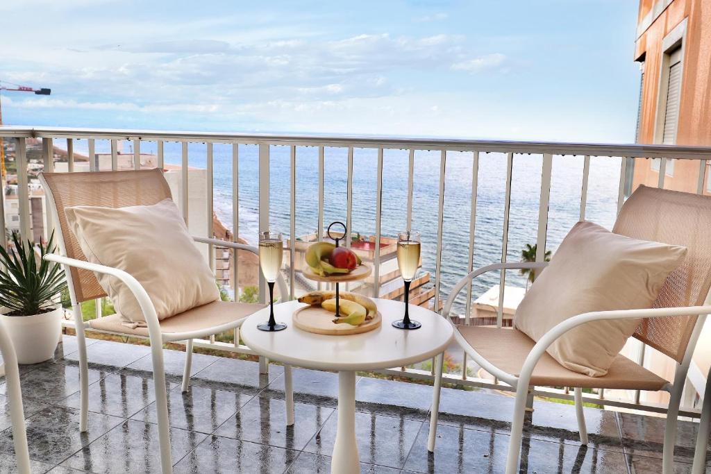 a table and chairs on a balcony with the ocean at Apartment with sea view in Cullera in Faro de Cullera