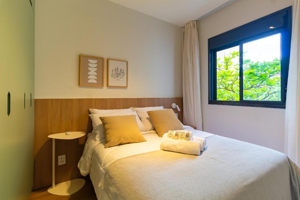a bedroom with a large bed with a window at CGB302 - Apto com piscina e academia Bela Vista in Sao Paulo