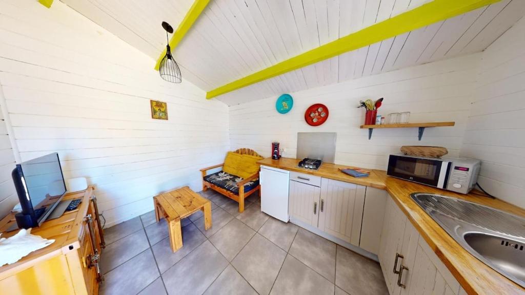 Una cocina con fregadero y un sofá en una habitación. en Ti Kaz, en Sainte-Anne