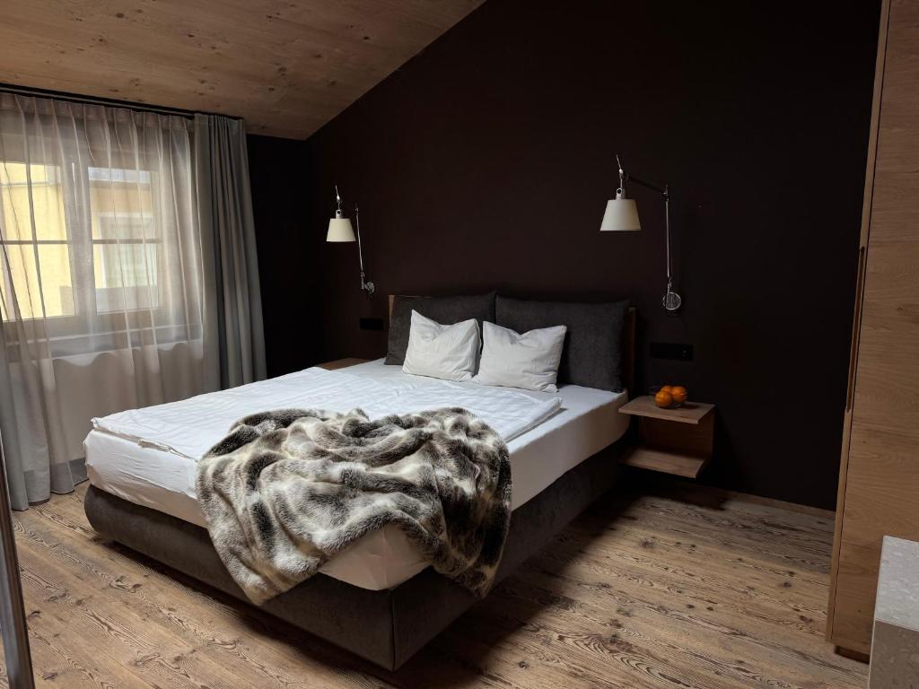 a bedroom with a bed with a blanket on it at La Maison 35 - Bruneck in Brunico