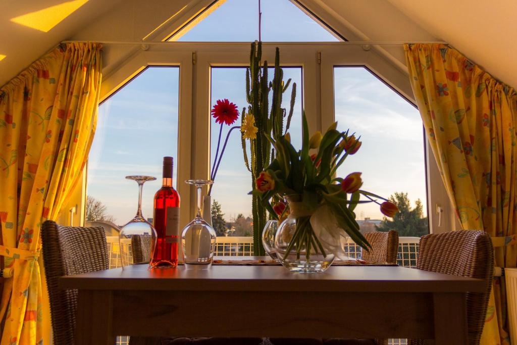 una mesa con un jarrón de flores y una ventana en Ferienwohnung Weber-Rolinger, en Andernach