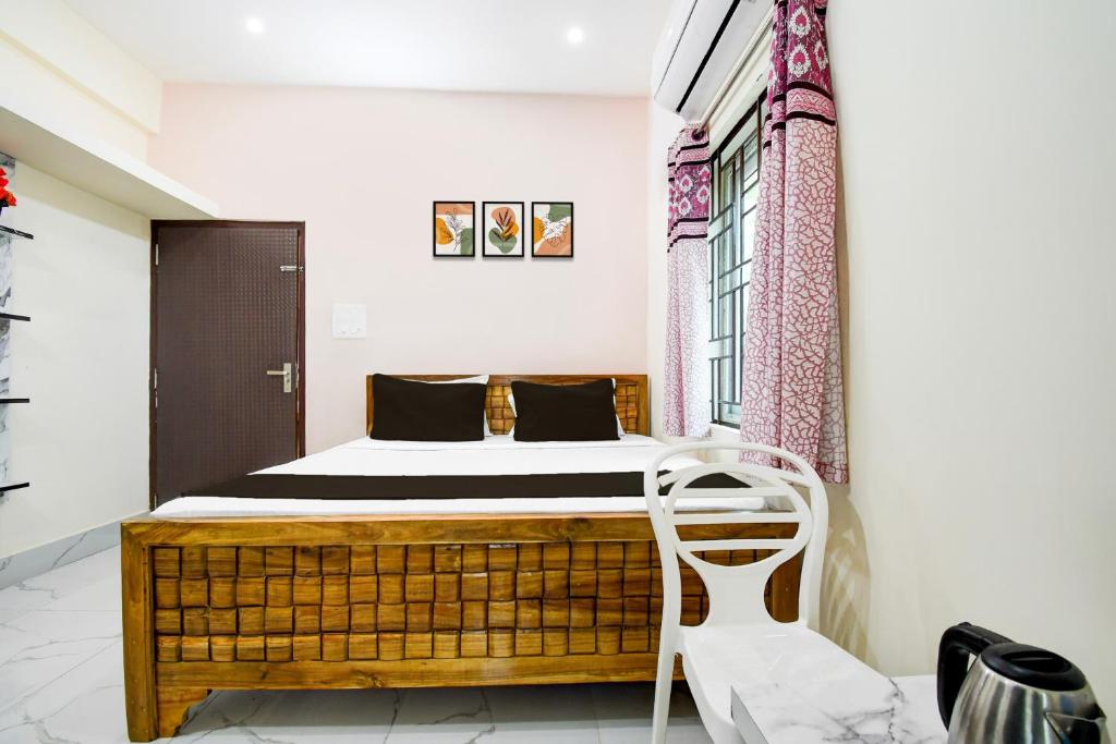 un dormitorio con una cama y una silla en Hotel O Shree Jagannath Residency, en Khandagiri
