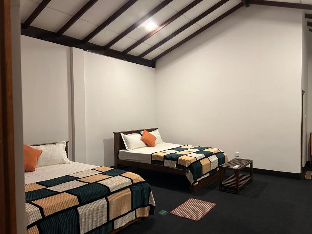 a room with two beds in a room at Thomasz Lodge 2 in Kandy
