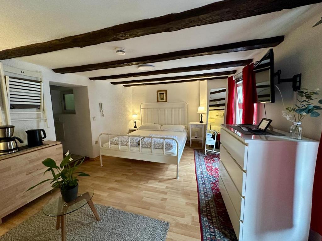 a bedroom with a bed and a dresser in a room at Baumeisterhaus Apartment in Bad Hersfeld