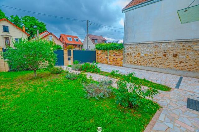 a backyard of a house with a basketball hoop at Location Cosy Paris - villa Emeraude in Sainte-Geneviève-des-Bois