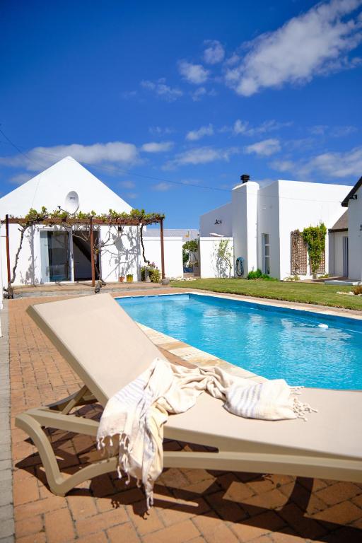 a white chaise lounge next to a swimming pool at MM Good Times in Gansbaai