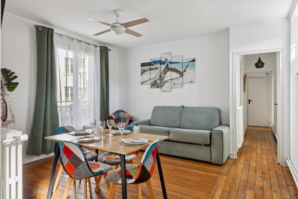 a living room with a table and a couch at Luxury Paris Apt, Metro 4 & RER B, 6 guests, CDG Access in Paris