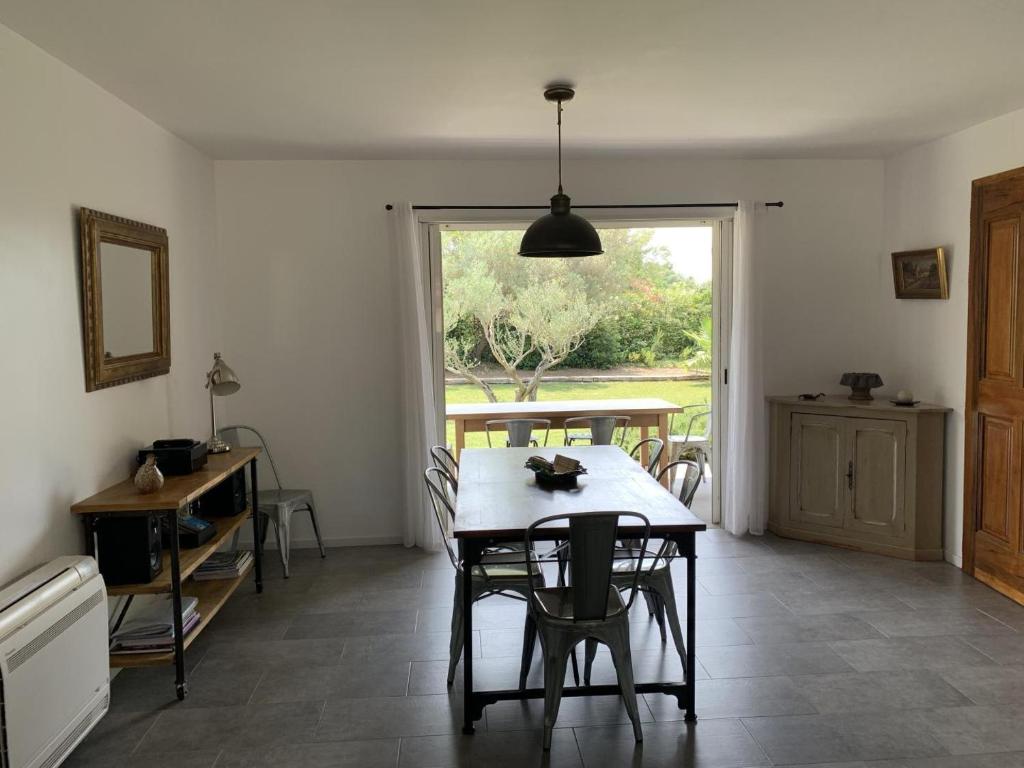 a dining room with a table and a window at Le mas saint augustin in La Crau