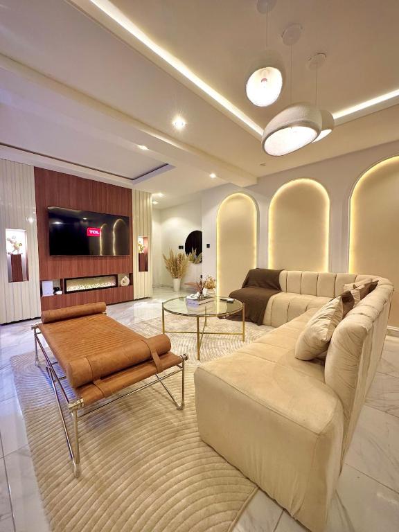 a living room with two couches and a flat screen tv at The Champagne Suite in Mama
