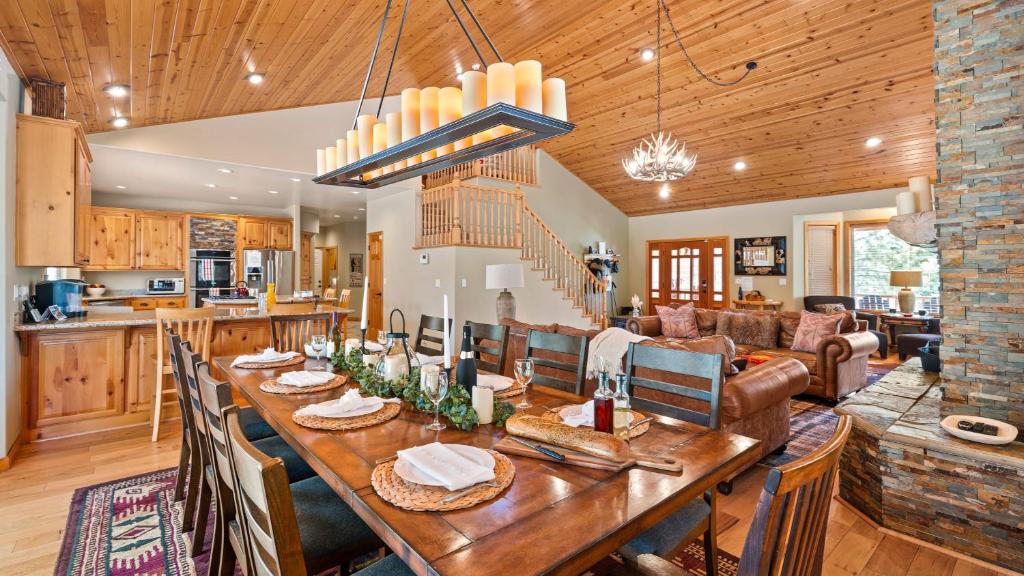 a dining room and living room with a large wooden table at Linaker Lodge by AvantStay Gorgeous Cabin in Big Bear w Views in Big Bear Lake