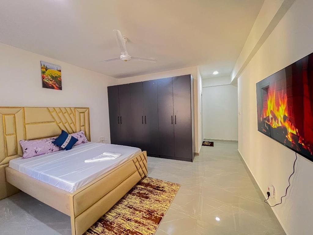 a bedroom with a bed and a painting on the wall at Madzo Holiday homes in Mombasa