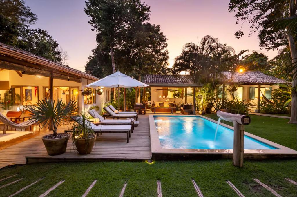 Un patio trasero con piscina y una casa. en Rest Place In Trancoso, en Porto Seguro