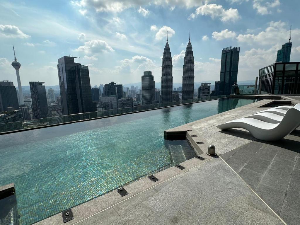 a swimming pool on top of a building with a city at Ikon Service Apartment at IMPERIAL in Kuala Lumpur