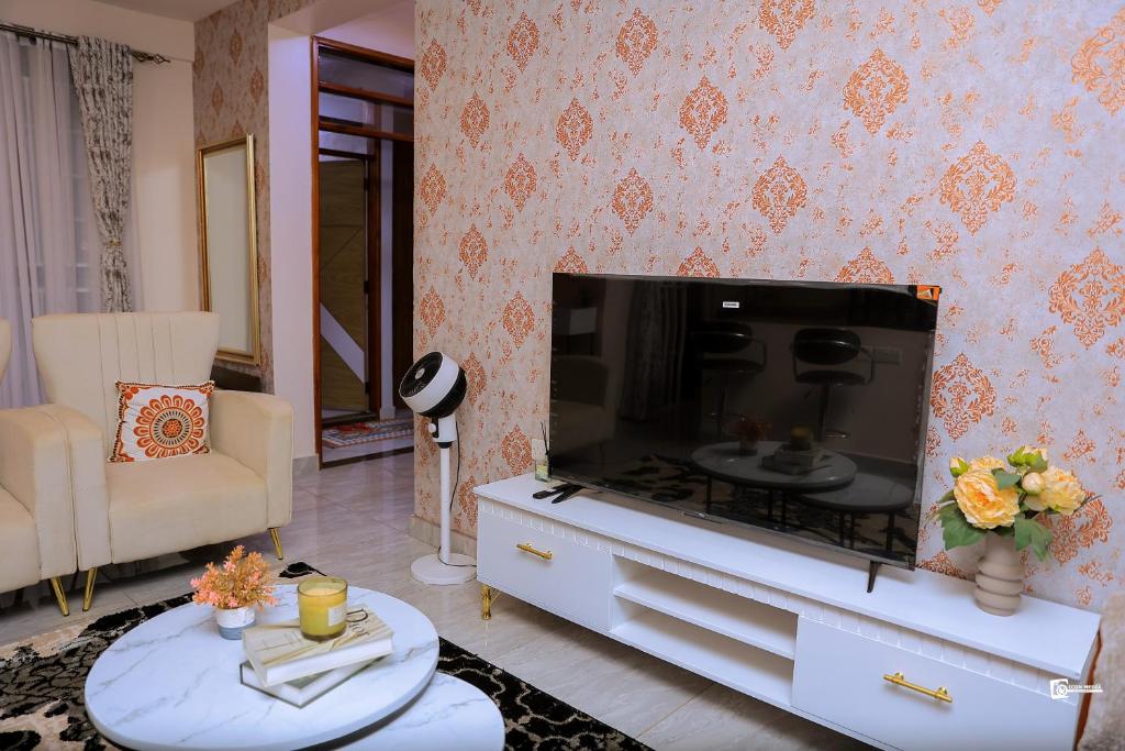 a living room with a large flat screen tv at Eliana Apartment in Kampala