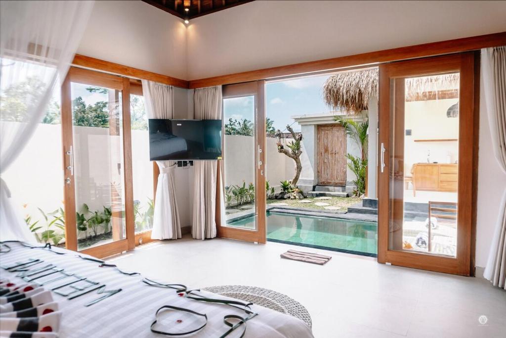 una camera da letto con un letto e una piscina di NaSya Villa Ubud ad Ubud