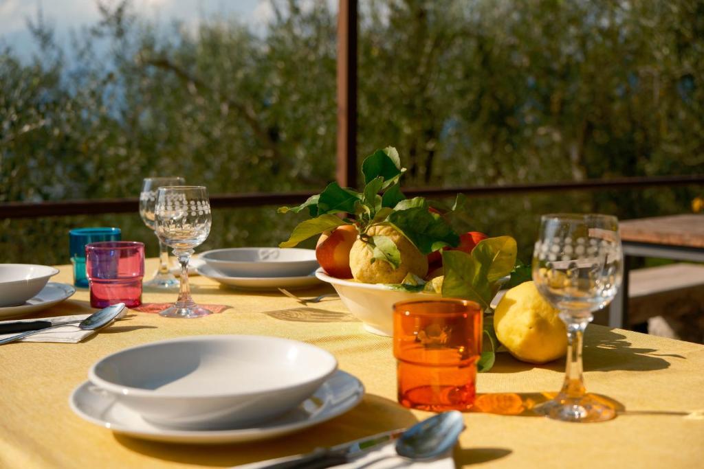 a table with plates and wine glasses on top of it at Welcome traveller Benaco Chalet in Torri del Benaco
