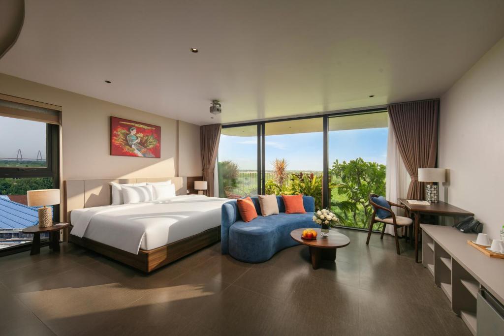 a bedroom with a large bed and a blue couch at Hanoi Riverview Boutique Hotel & Apartment in Hanoi