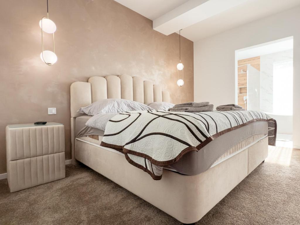 a bedroom with a large bed with a large headboard at LuxHome by Lake Neusiedl with Jakuzzi in Fertőszentmiklós
