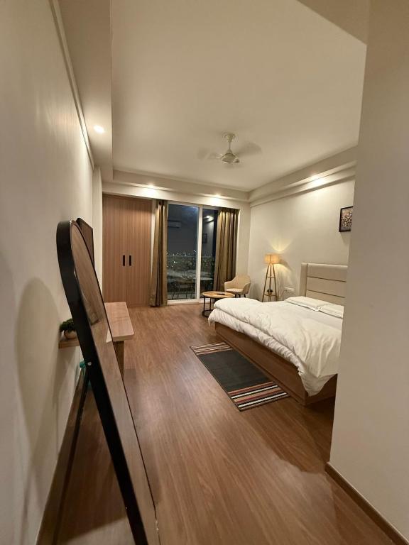 una habitación de hotel con una cama y una ventana en NCRstay, en Greater Noida