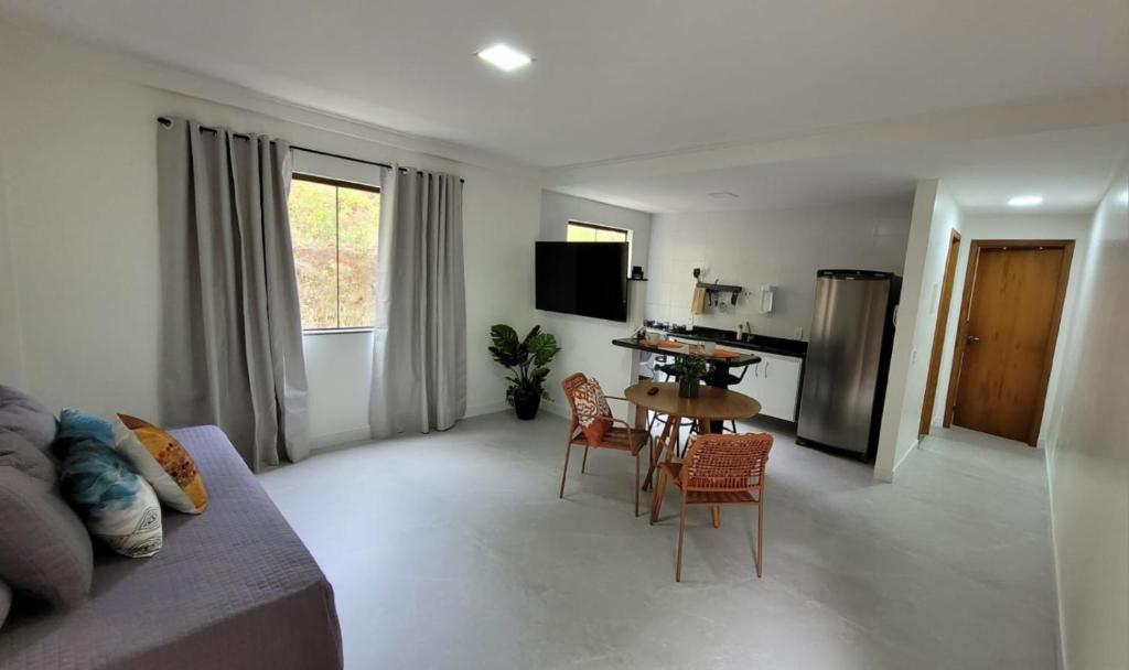 a living room with a couch and a table and chairs at Apartamento Charmoso de 1 quarto em Domingos Martins in Domingos Martins
