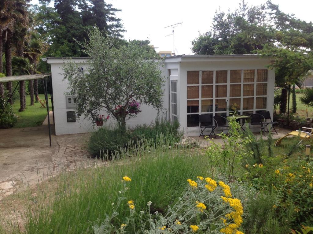 un jardin en face d'un bâtiment blanc dans l'établissement Holiday House Altea, à Banjole