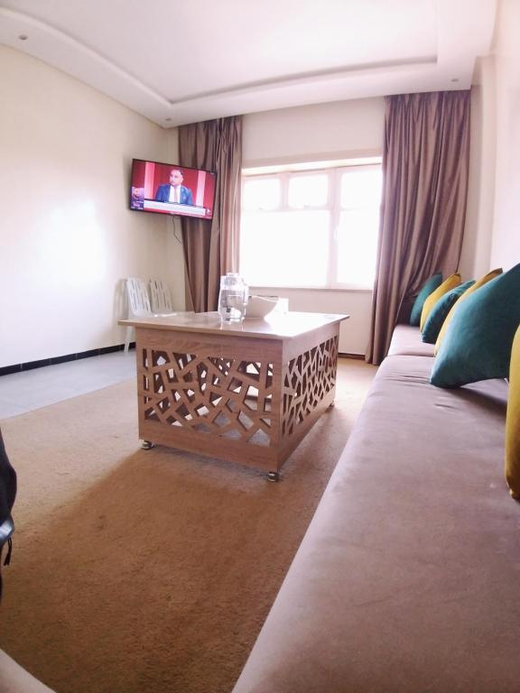 una sala de estar con un sofá y una mesa en Residence el michouar, en Laayoune