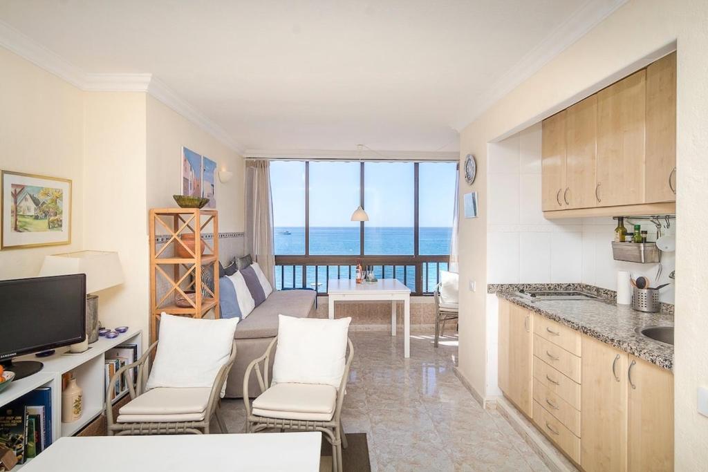 a kitchen and living room with a view of the ocean at Seafront Studio in Patalavaca