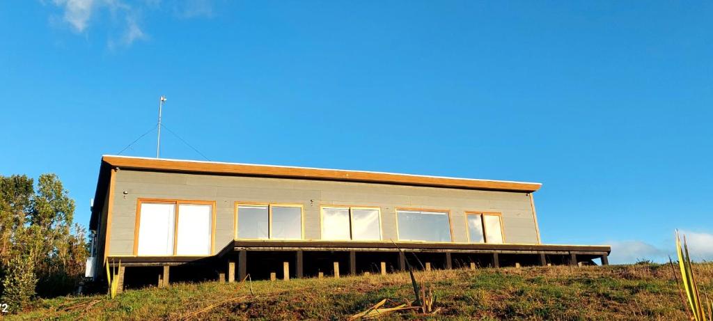 a house sitting on top of a hill at Casa de campo chiloe pugueñun ancud in Ancud