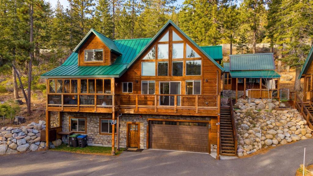 une maison avec un toit vert et un garage dans l'établissement Denton by AvantStay Hot Tub Deck w Fire Pit Near Skiing Lake, à Truckee