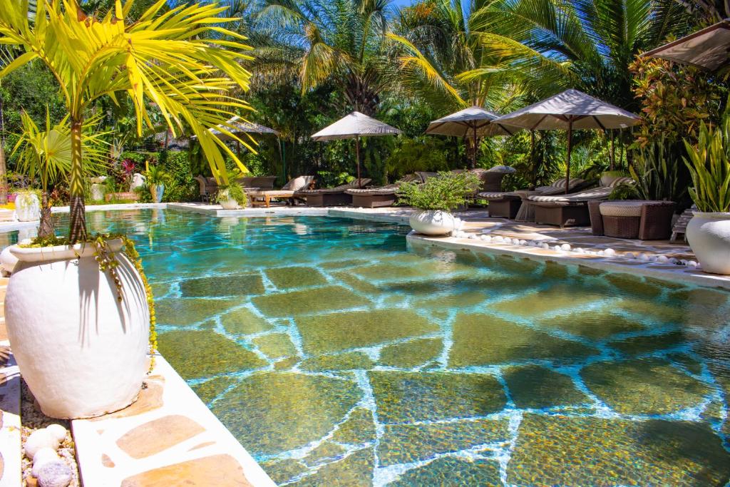a swimming pool in a resort with palm trees at Manaya Luxury Sunset & Serenity Serviced 2Bedroom by Diani Beach with Pool & Parking in Galu