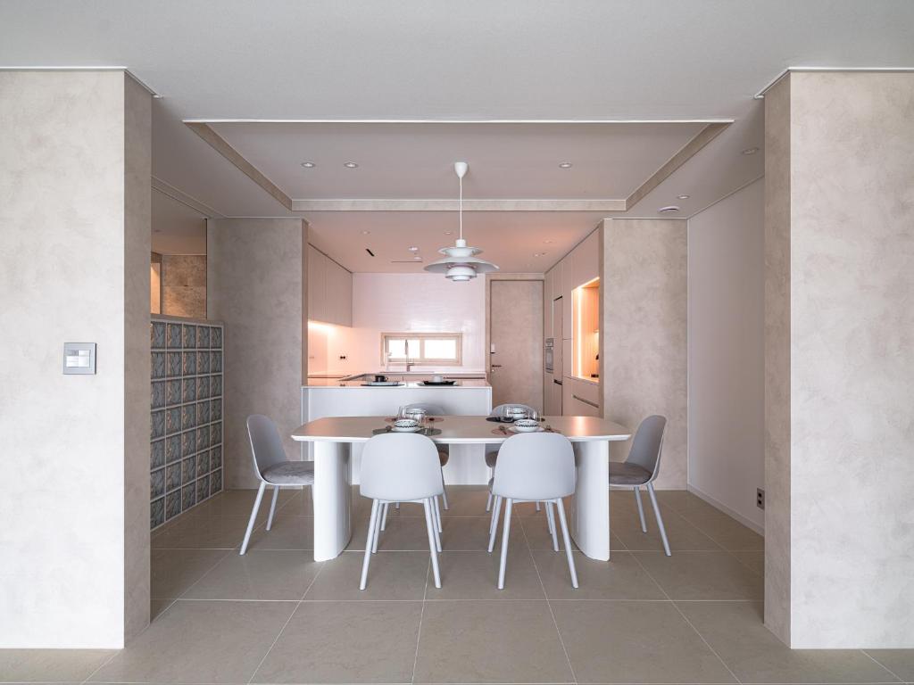 釜山にあるStay Villette Haeundaeのテーブルと椅子のあるキッチンとダイニングルーム