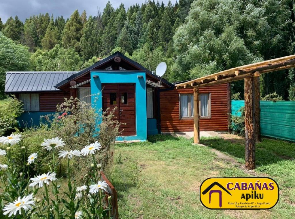 una cabaña de madera con un jardín frente a ella en Cabañas Apiku, Lago Puelo, en Lago Puelo