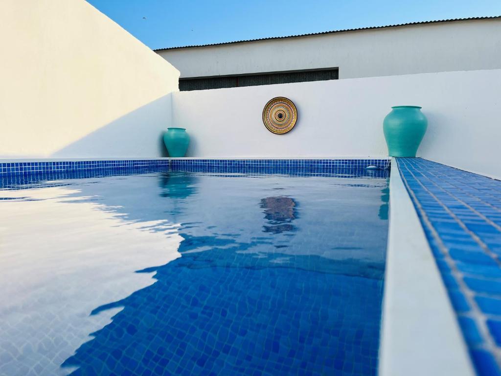 a swimming pool with blue tiles on the side of a building at Casa da Mó - Conforto, Charme e Piscina privada no Coração do Alentejo in Beringel