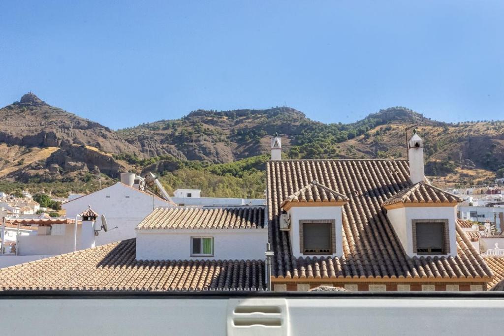 a view of roofs of buildings with mountains in the background at NT Bright and modern apartment in Pizarra in Pizarra