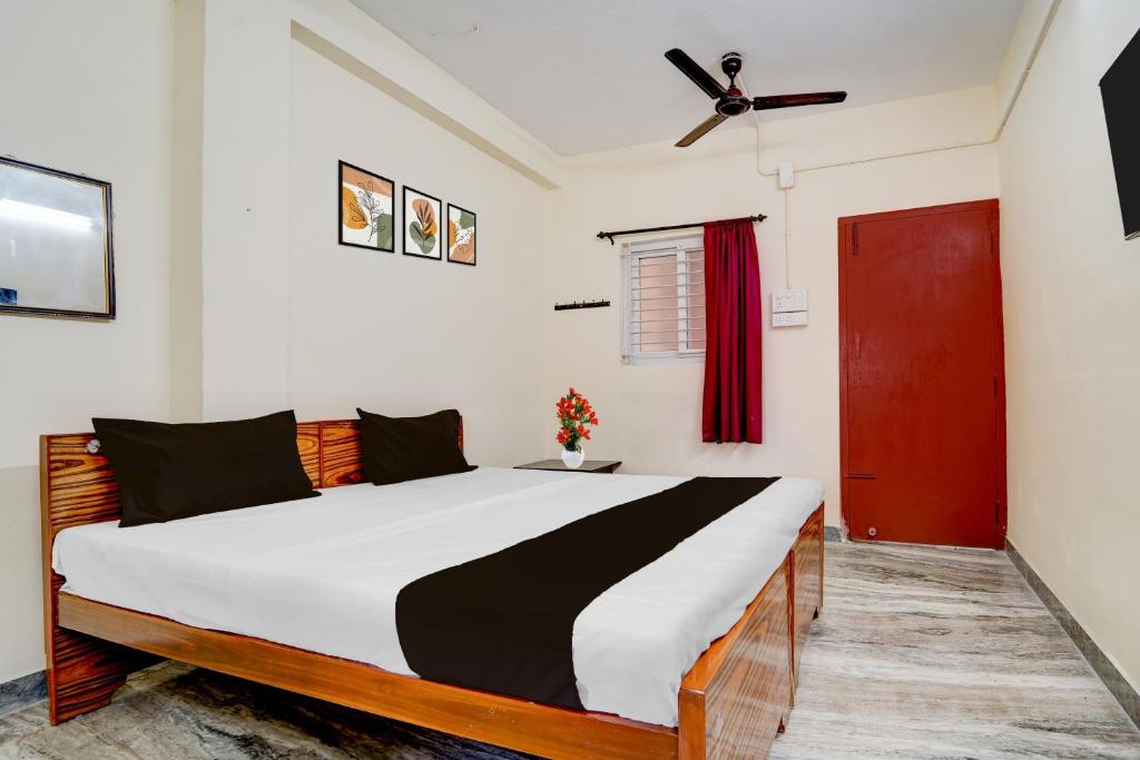 1 dormitorio con 1 cama grande y puerta roja en Collection O Avarampalayam Bus Stop Formerly Krish Castle, en Coimbatore
