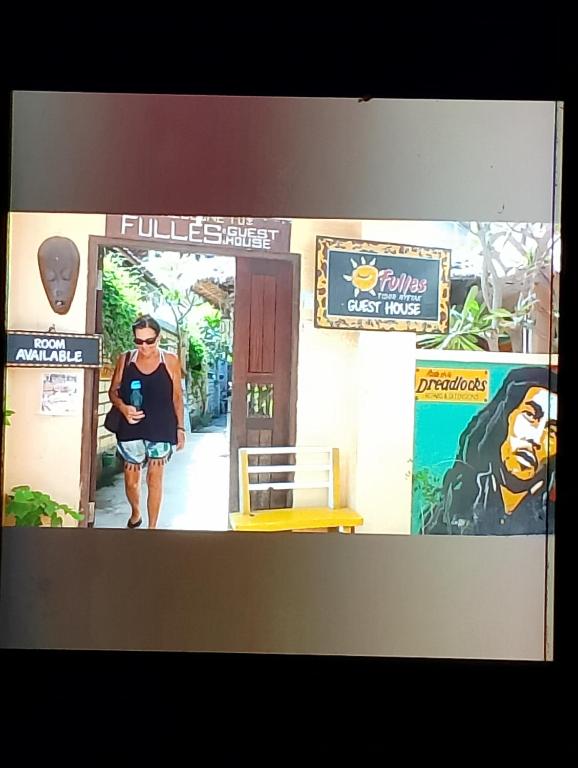 a woman standing in a doorway of a building at fulles guest house in Gili Trawangan